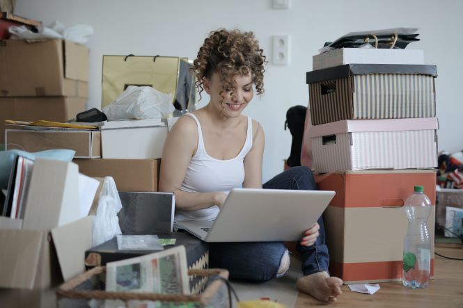 hispanic woman shopping online surrounded by boxes and bags